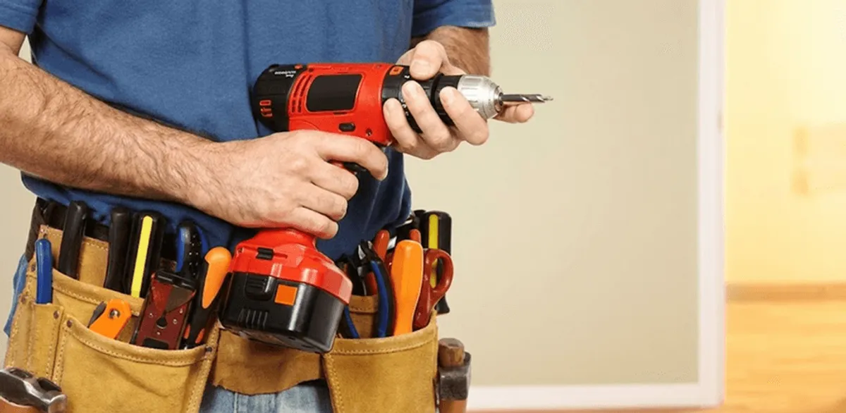 Handyman holding a power drill for home repairs and installations in Fresno, CA